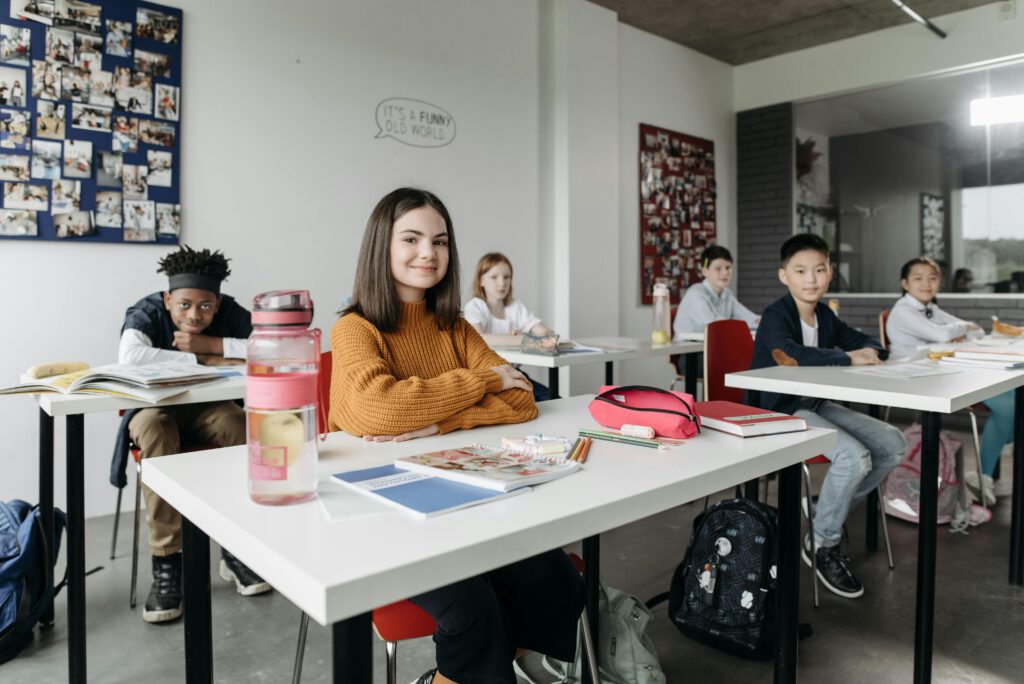 A diverse group of students studying together in a modern classroom setting, engaged in learning and collaboration.